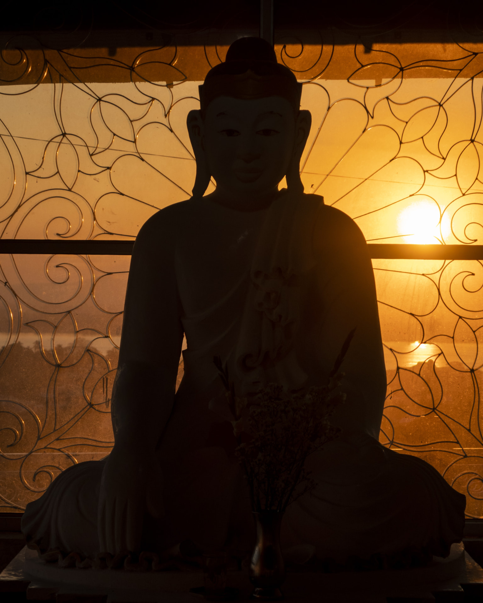 Silhouette of a seated Buddha statue at sunset in Mawlamyine